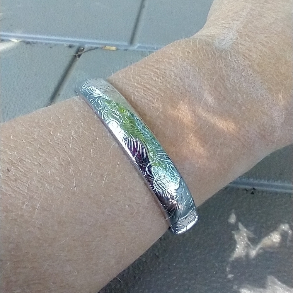 Women's hinged silver tone bracelet missing chain.